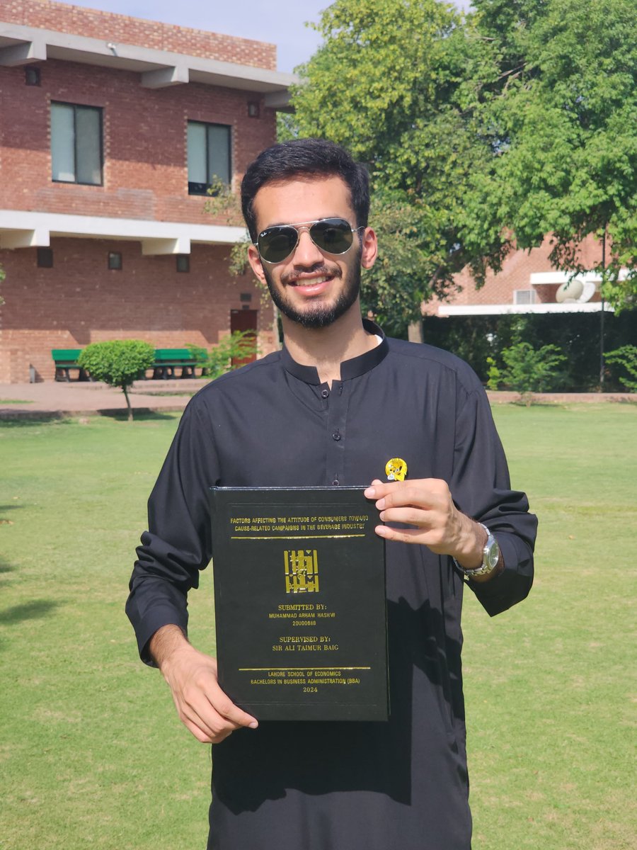 Muhammad Arham Hashmi in 2024, holding his bound BBA thesis at LSE